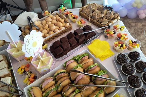 Mesa de festa com salgados, doces e frutas